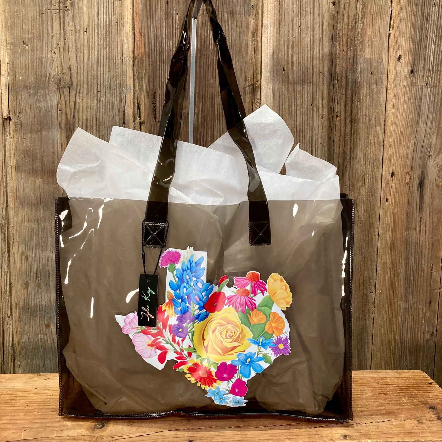 colorful jelly tote bags featuring the vibrant Texas Floral artwork by muralist Tyler Kay. Artwork is of a white Texas background covered by colorful Texas wildflowers.

choose from clear, black, blue, or white.

15.5" x 12"