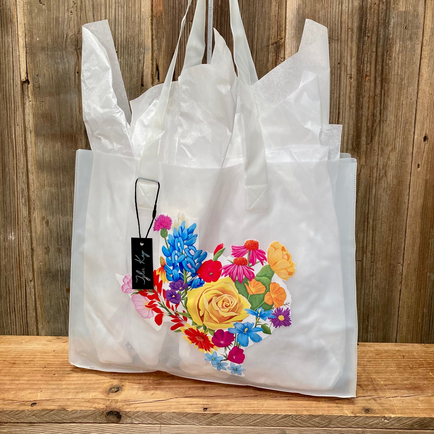 colorful jelly tote bags featuring the vibrant Texas Floral artwork by muralist Tyler Kay. Artwork is of a white Texas background covered by colorful Texas wildflowers.

choose from clear, black, blue, or white.

15.5" x 12"