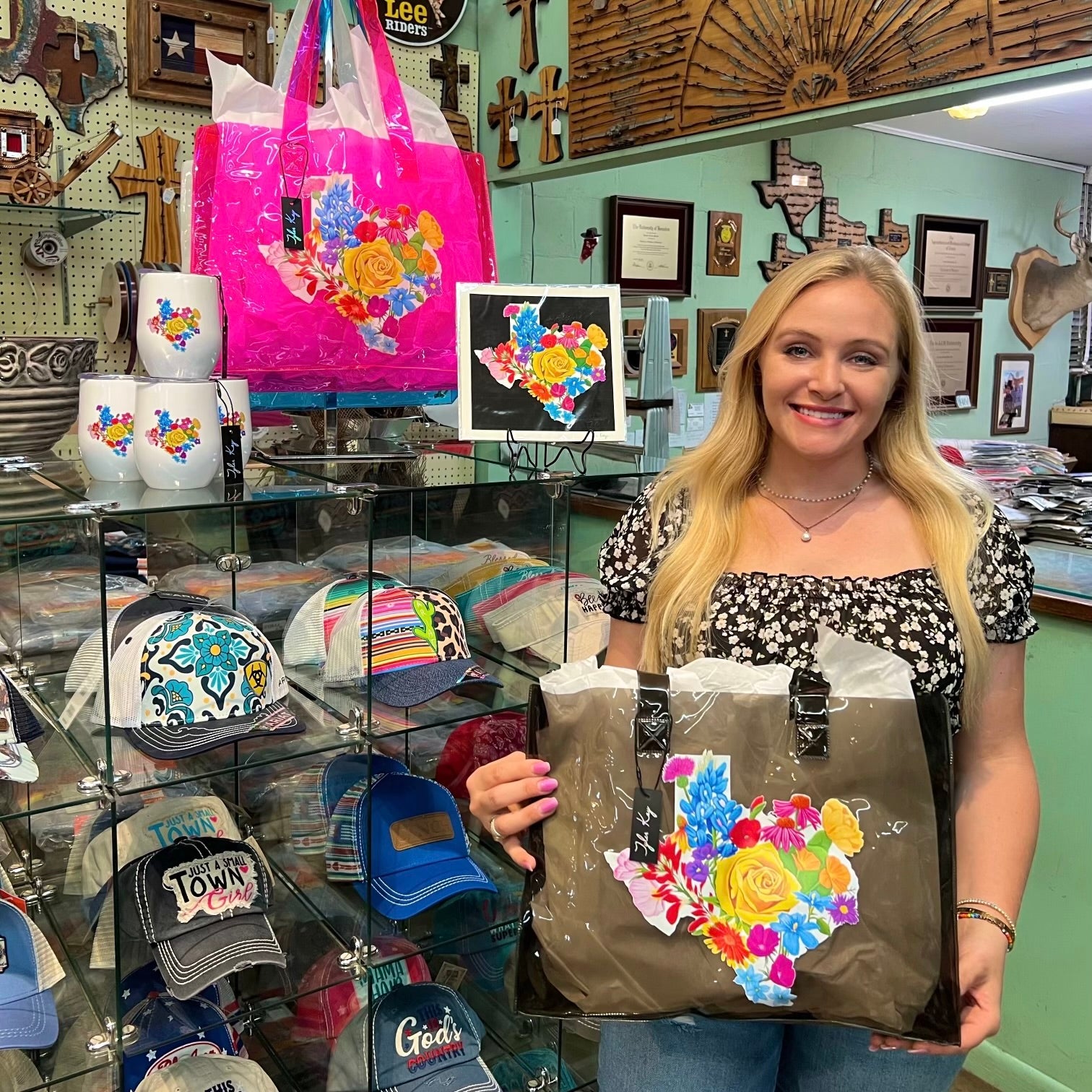Tyler Kay holding Texas Floral gift bags and products featuring the Texas floral artwork.