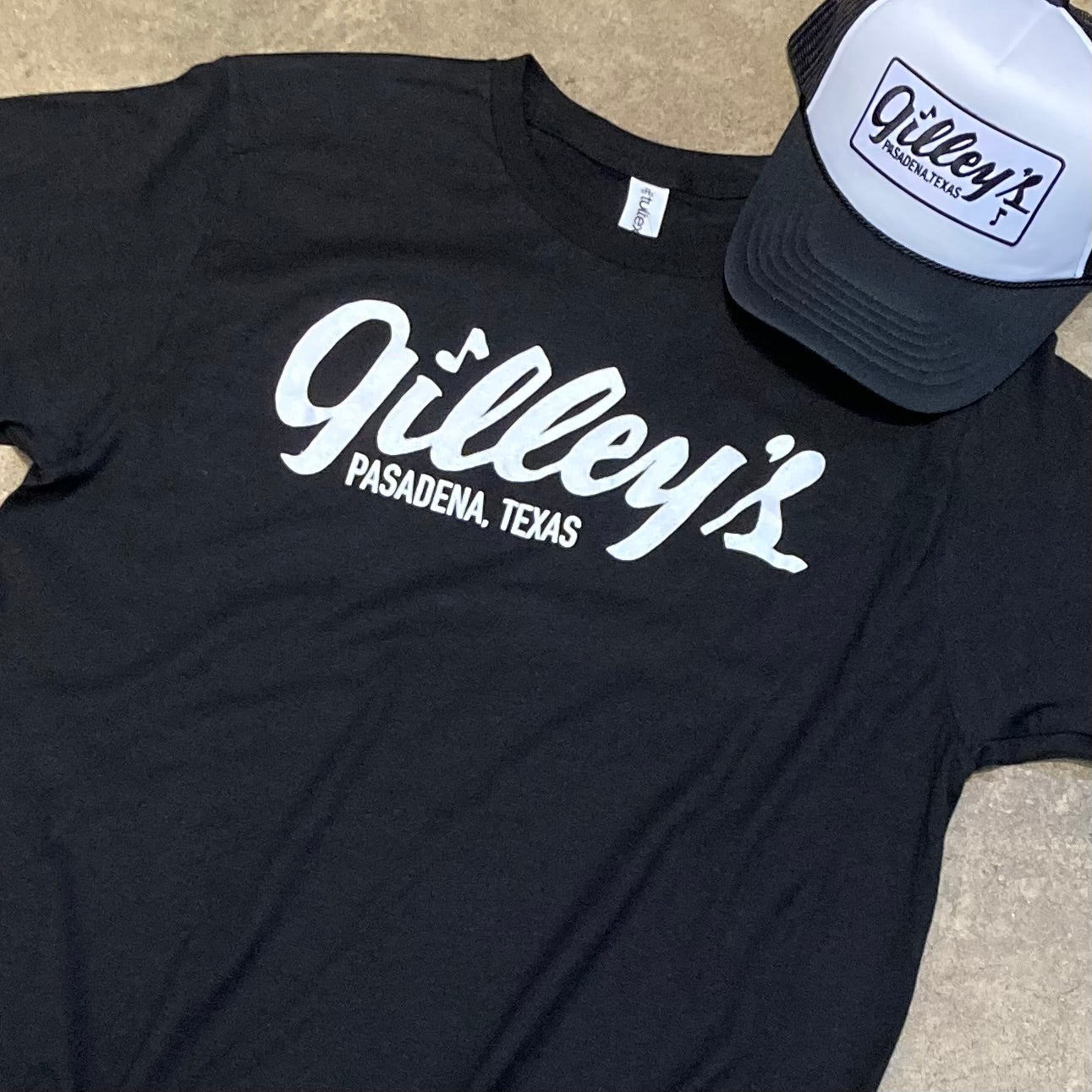 black gilleys t-shirt with white pasadena texas logo laid flat on the floor