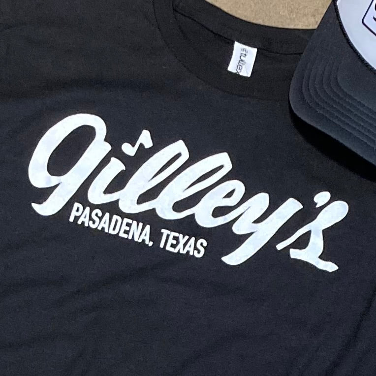 close-up of white gilleys pasadena texas logo on black t-shirt