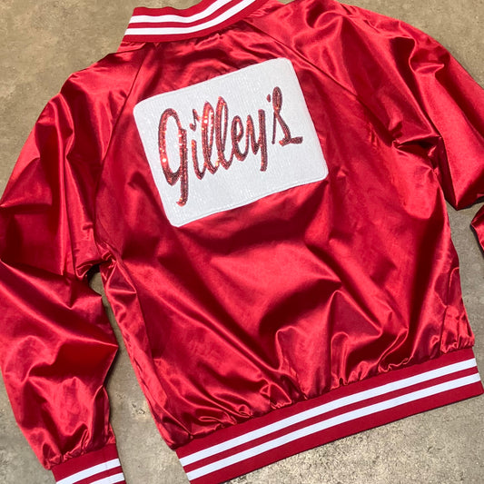 Close-up of the back of the Gilley’s Red Satin Jacket featuring a sparkling sequin logo patch and retro striped rib-knit accents. Perfect for a stylish statement look.