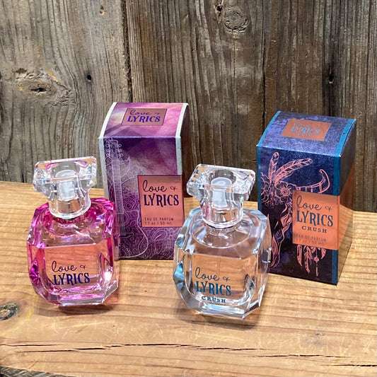Love & Lyrics Perfumes in pink and clear bottles, featuring vibrant, fruity scents with notes of raspberry, peach, and creamy sandalwood. 1.7 oz each.