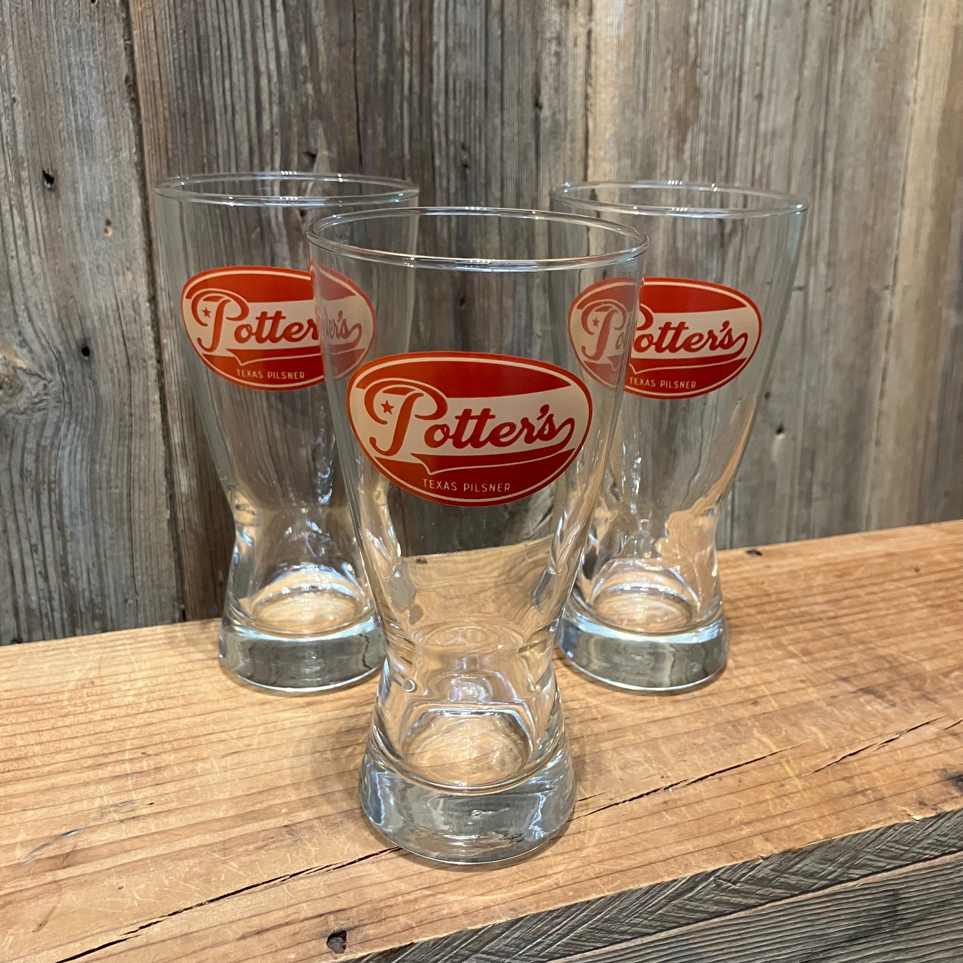 Three Potter’s Pilsner glasses with retro logo