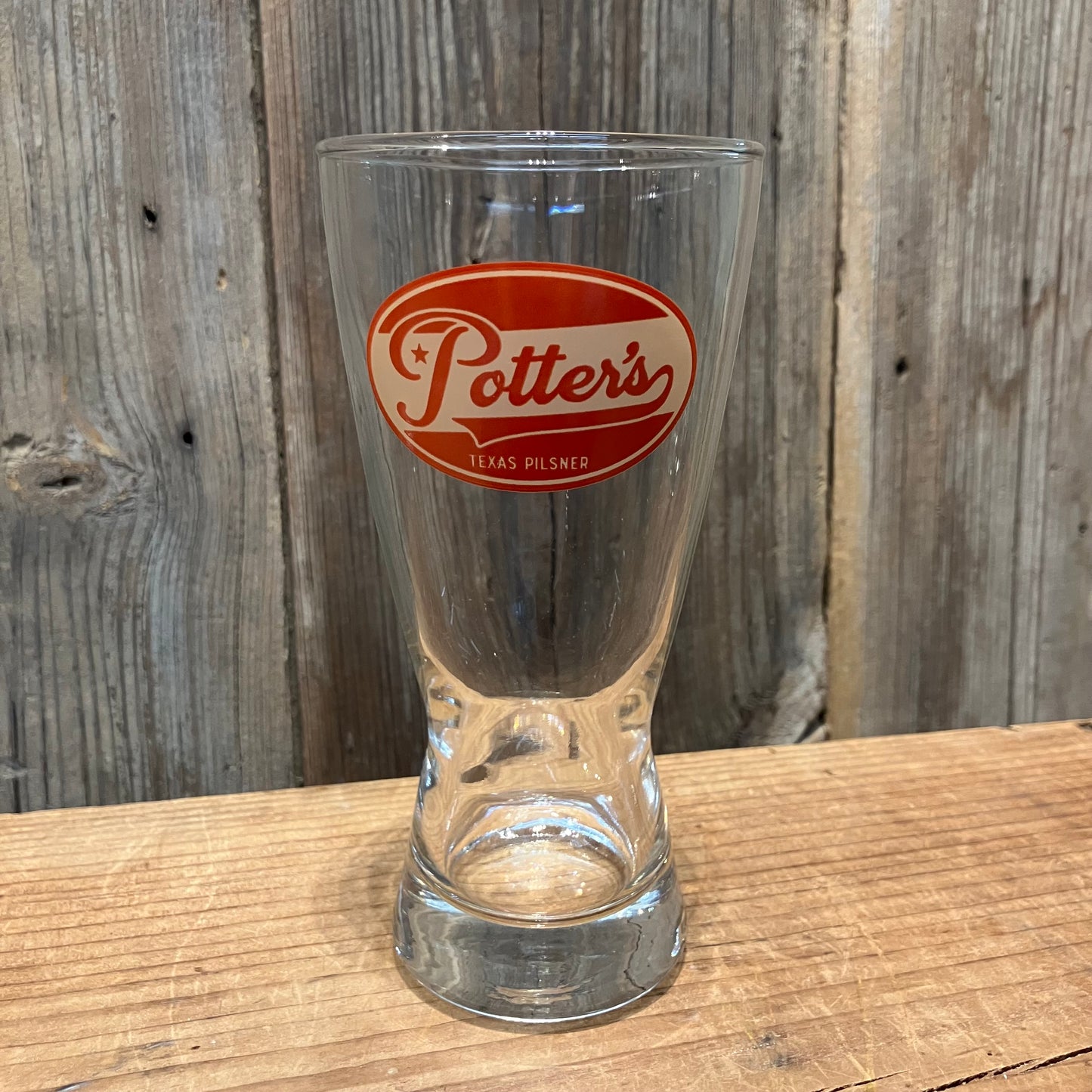 single Potter’s Pilsner pint glass with red logo