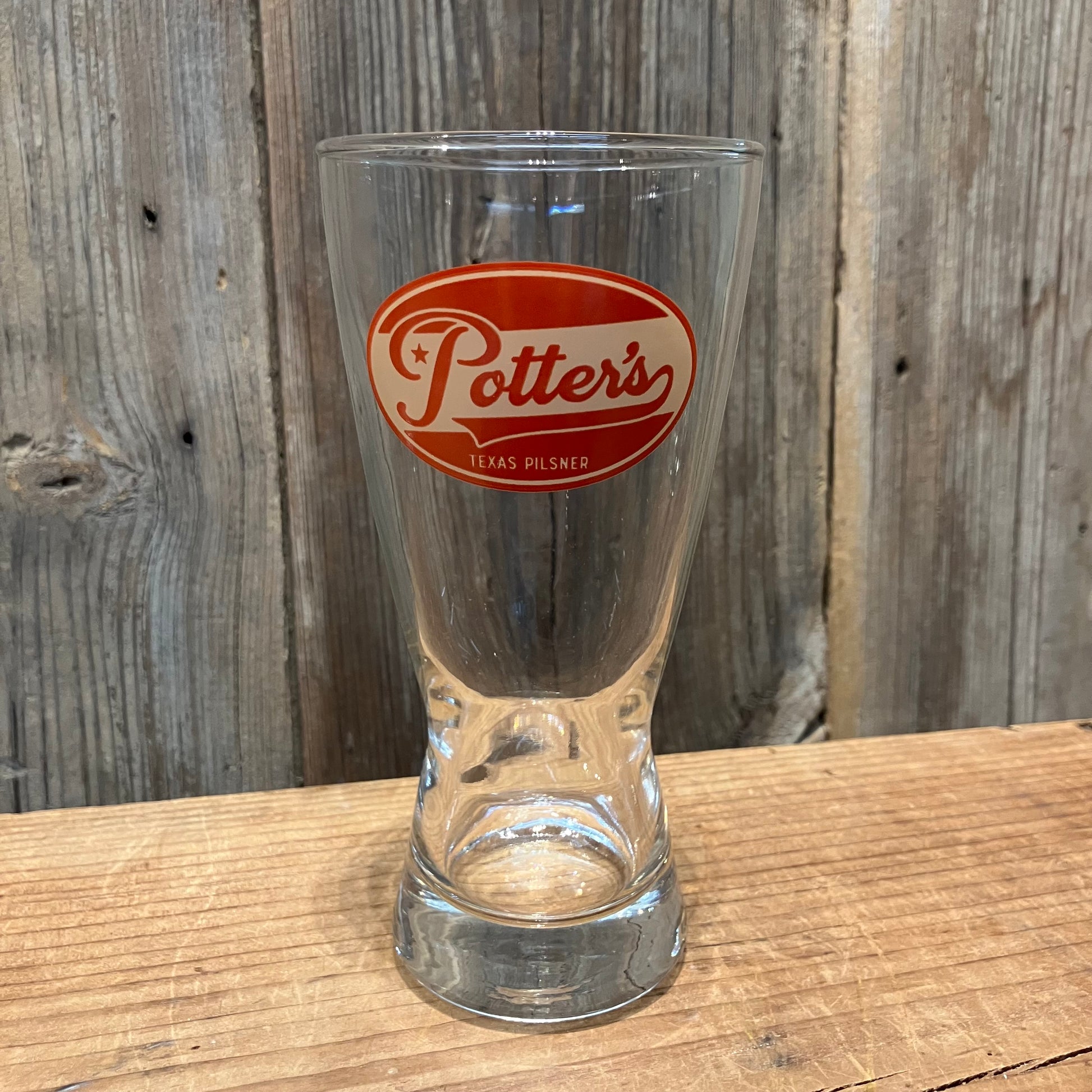 single Potter’s Pilsner pint glass with red logo