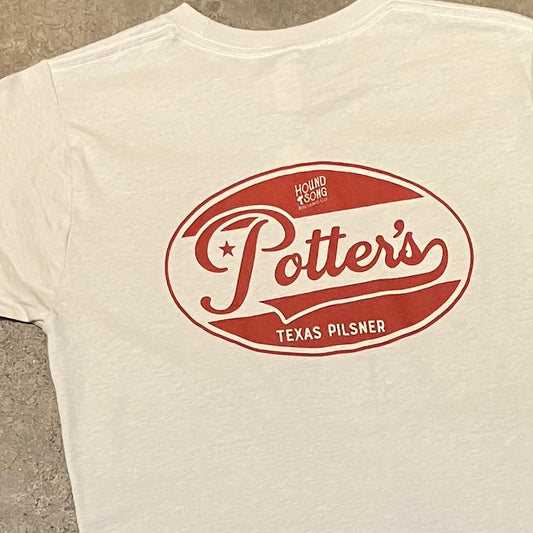 closeup of red Potter’s Texas Pilsner logo on back of cream t-shirt