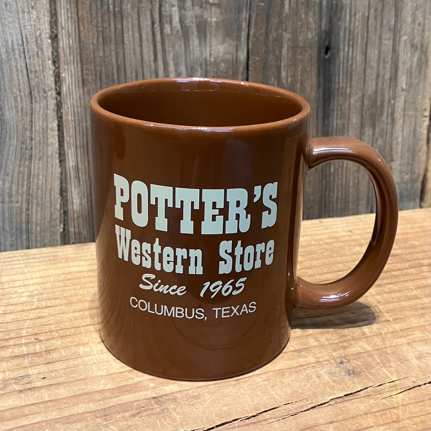 brown mug with white Potter’s Western Store logo and Columbus, Texas text on back